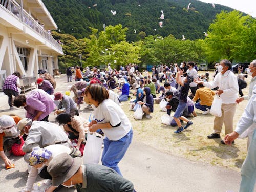 お祝いの”餅投げ”には地域の方がたくさん集まりました。