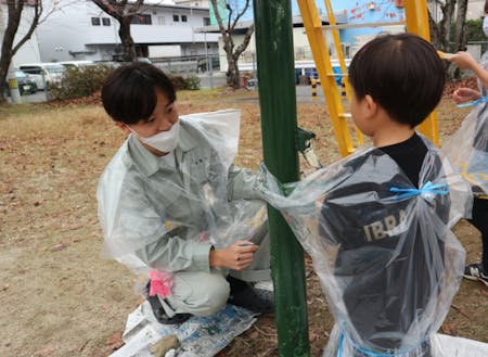 学生が企画した「地域の人の思い出に残る公園を作る」ことを目的にした公園遊具塗装イベントの様子（左側男性）