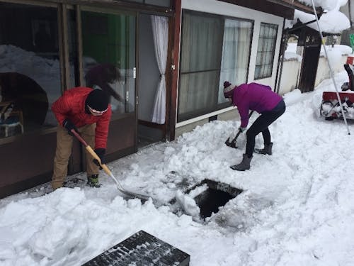 積もった雪を流雪溝に流す様子