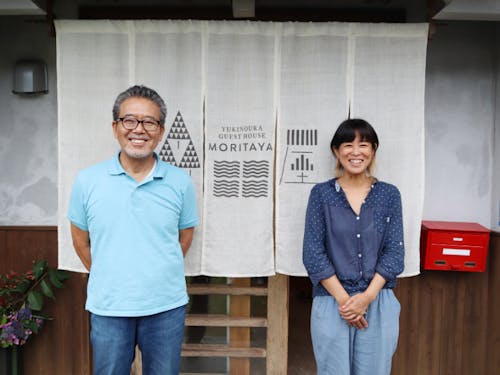 「株式会社ゆきのうら」事務局の渡辺さんと荒瀬さん。事務局のある「ゲストハウス森田屋」の前で