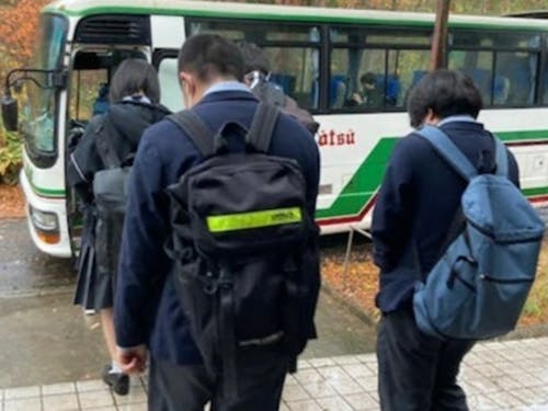 スクールバスでの登校風景です。毎日ハウスマスターが見送ります。