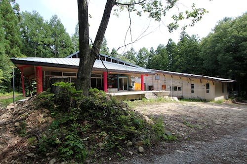 ホテルや民宿から離れた森の中に立地する鉄骨造280坪の建物