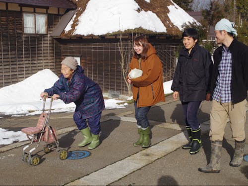 集落のお母さんとおしゃべりしながら一緒に歩く村・留学参加者