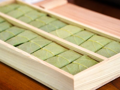 包み終わったものを木の箱に入れて、ぎゅっと押すと完成します。(だけど、包むのも難しいし、箱に入れている途中に広がったりもして難しい…!)