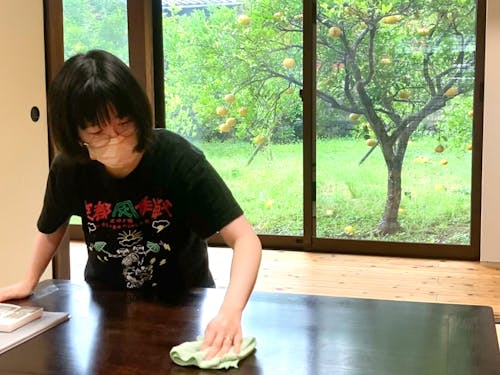 古民家をリノベーションした一棟貸しの宿で、現代風にお掃除ロボットも使いながらピカピカに磨きあげる田才さん。