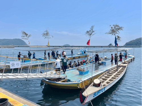 普段はノリ養殖に使用している船から艇に乗り込む選手たち
