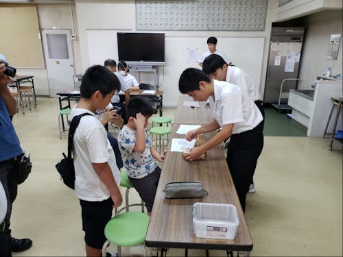 第1弾企画でプログラムしたゲームの説明をする生徒の様子