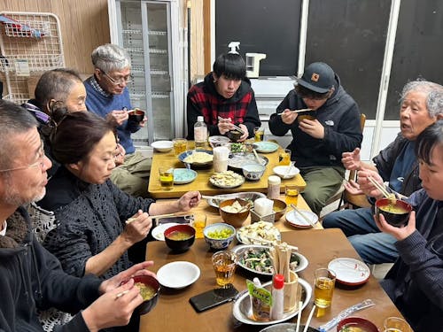 地域の人と一緒に地元食材を使った料理を作って食卓を囲む