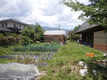 写っているのは、畑にヤギに、子どもに古民家、ニワトリに薪