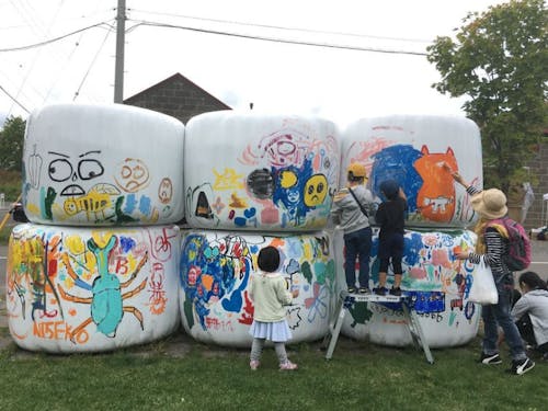 マルシェイベントの1コーナーでは、牧草ロールにみんなでペイント。協力隊OGのアーティストがサポート