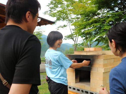 魚梁瀬地区のキャンプ場で、ピザ窯について説明している西尾さん。西尾さんは他にも魚梁瀬ダムでのSUPなど、魚梁瀬地区にある資源をいかした新しいアクティビティにチャレンジしています。