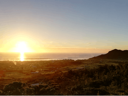 雄大な海に沈む夕陽と寝姿山