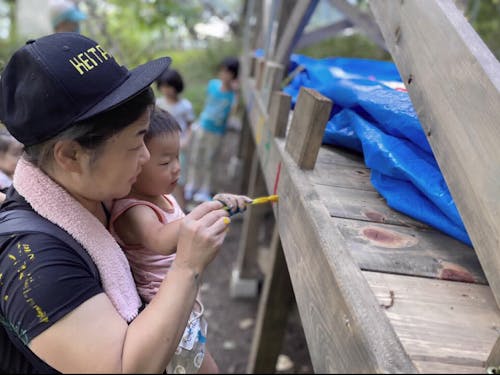 地域のみんなでつくったウッドデッキに、子どもと楽しみながら絵を描くゲストの木下さん