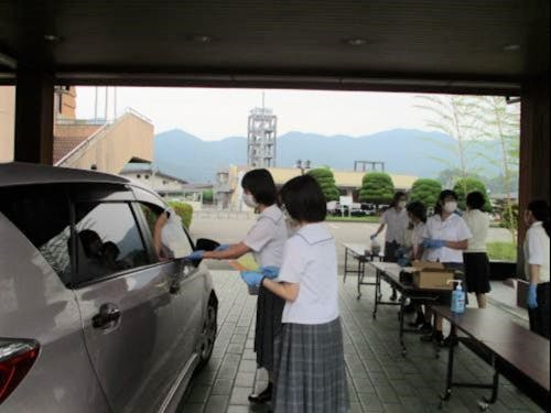 コロナ禍で町内飲食店を支援するために、高校生が発案したドライブスルー形式の助け合いマルシェの様子