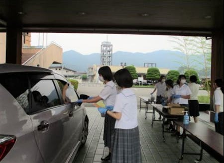 コロナ禍で町内飲食店を支援するために、高校生が発案したドライブスルー形式の助け合いマルシェの様子