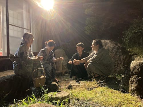 縁側で浴衣を着て線香花火をする住人達